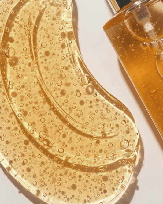 Close-up of a skincare product with a gel-like texture and bubbles, next to a bottle of the product.